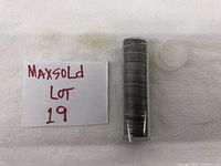 A clear plastic coin tube filled with Lincoln wheat pennies on white background next to a card showing MaxSold Lot 19.