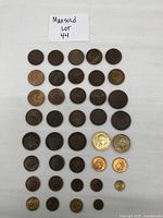 Full view of 31 assorted Mexican coins laid out in rows on white background