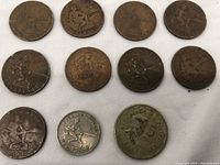 Top view of nine Philippines coins from 1944 with visible varying wear; combination of 1 Peso and one larger 5 Peso coin.