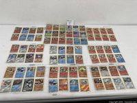 Wide layout of about 70+ assorted Pokémon shiny cards, showing varied colors with metallic, silver, and gold effects on the table.