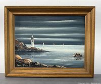 Framed original signed painting showing lighthouse, rocky coast, and sailboats with moody sky.