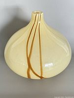 Photo of MCM art glass vase showing bulbous cream body with brown drip lines and narrow neck.
