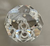 Top view showing the faceted crystal and clear internal sculpted design resembling a symbolic shape.