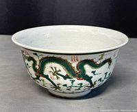 Side view of the bowl showing dragon designs and overall shape.