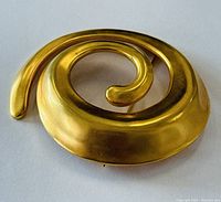 Front view of the gold-tone spiral brooch showing the smooth matte finish and spiral design.