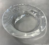 Side angled photo showing overall shape, clear crystal with detailed lion head design on the rim.