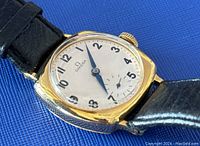 Close-up of silver dial, black Arabic numerals, blued hands and small seconds subdial