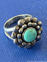 Close-up photo of vintage turquoise and silver ring showing textured silver bead design around round turquoise stone and silver band.