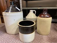 Set of four stoneware crocks showing varying sizes and glazing styles, largest marked with number 3.