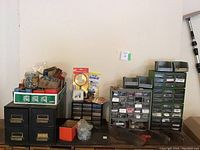 Overview of hardware organizers, file cabinet drawers, jars, and boxes showing various fasteners and tools.