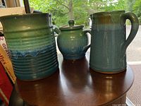 All three pottery pieces together on table showing size and style differences