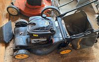 Side view of Poulan Pro self-propelled gas lawn mower with grass catcher bag