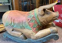 Side view of the carved rocking pig showing the decorative collar and rocking base.