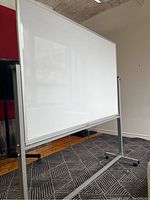 Front side of dry erase whiteboard with white melamine surface and aluminum frame on stand.