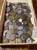 Top view of mixed foreign coins showing various denominations and countries of origin.