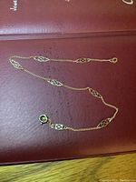 Full view of the gold bracelet laid out showing chain and decorative links.