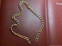 Full view of chain bracelet arranged on a red book