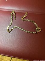 Full view of bracelet laid out on red surface showing link pattern and length