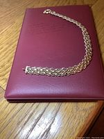 Full view of 10k gold bracelet laid out straight on red pad