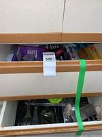 Photo of three drawers partially open displaying an assortment of kitchen storage items including food wraps, bags, utensils, and accessories.