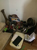 Wide view of barometer, HP printer, assorted pens and office supplies in bins and cups on wood surface near stairs.