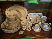 Full lot featuring Royal Albert Lavender Rose patterned china including plates, cups, saucers, gravy boat, cake plates, cream and sugar, salt and pepper shakers, plus Royal Albert Petite Point pieces and a large Alfred Meakin platter.