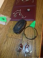 Overview photo showing all items in the lot including earrings, trinket box, ring, and bracelets on a wooden floor.