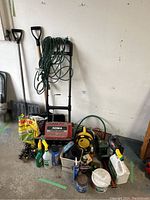 Wide view showing Noma TurboThrower 1500 snow thrower, extension cord on caddy, shovels, and assorted garden products