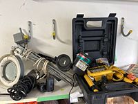 Side view showing magnifying work light on articulated arm, coiled cord, and telescoping work light case with yellow Star Shower projectors inside.