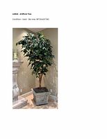 Full view of large artificial tree with lush green leaves in decorative planter against a wall corner.