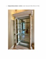 Front angled view of the display unit/case cabinet showing glass shelves, mirrored back, and decorative columns.