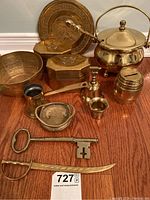Photo shows entire lot arranged on floor, includes embossed plate, large key, sword, bowl, bank, bell, hinged boxes, pourer, ash bucket with lid and shovel.