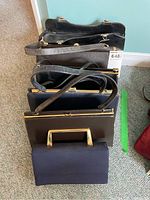 Top view of the five handbags standing upright showing different sizes and handles.