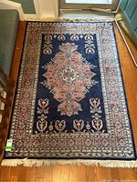 Overhead view of entire rug laid on hardwood floor near door and bench