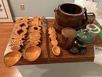 Full lot overview showing spoons, wooden bucket, copper tin, cloisonné boxes and jar, cowbell, and marble box