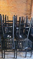 Multiple stools stacked showing metal frames and slatted backrests