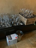 Photo showing boxed and loose martini glasses on a tray with two chrome wine chillers adjacent.