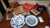 Full view of lot on table including copper bowl, pottery, brass vase, Blue Willow dish, Christmas trays, and trinket boxes.