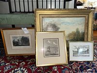 Group view of one large painting and three framed prints on patterned carpet