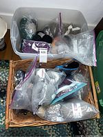 Overall view of two storage containers filled with assorted yarn skeins in various colors and packaging types.
