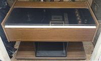 Closed view of vintage Admiral stereo console with wood finish and glass/plastic cover.