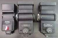 Photo showing all three Vivitar camera flash units side by side: Auto Focus Zoom 729AFC at left, Zoom Thyristor 285 in center, Zoom Thyristor 285HV at right.