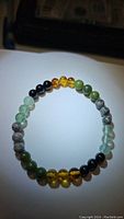 Photo of round 6mm beads bracelet featuring mixed gemstones including amber, onyx, jade, fluorite, and jasper on stretchy cord.