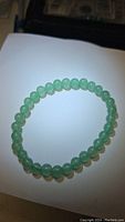 Circular stretchy bracelet made of polished natural green aventurine beads, evenly sized at 6mm each