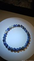 Top view of a natural blue sodalite bead stretchy bracelet with evenly sized 6mm beads showing blue and white veining patterns.