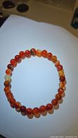 Natural red agate beaded stretchy bracelet laid flat showing bead color and size