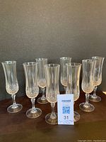 Group photo of 8 Cristal d'Arques Longchamp champagne flutes arranged in two rows in front of a dark background