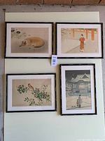 Four framed Japanese prints arranged on a table or floor, showing full view of frames and artwork.