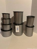 Front view of all eight Tupperware canisters arranged grouped by size.