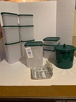 Full view of most containers and green ice bucket with lids, and container labels.